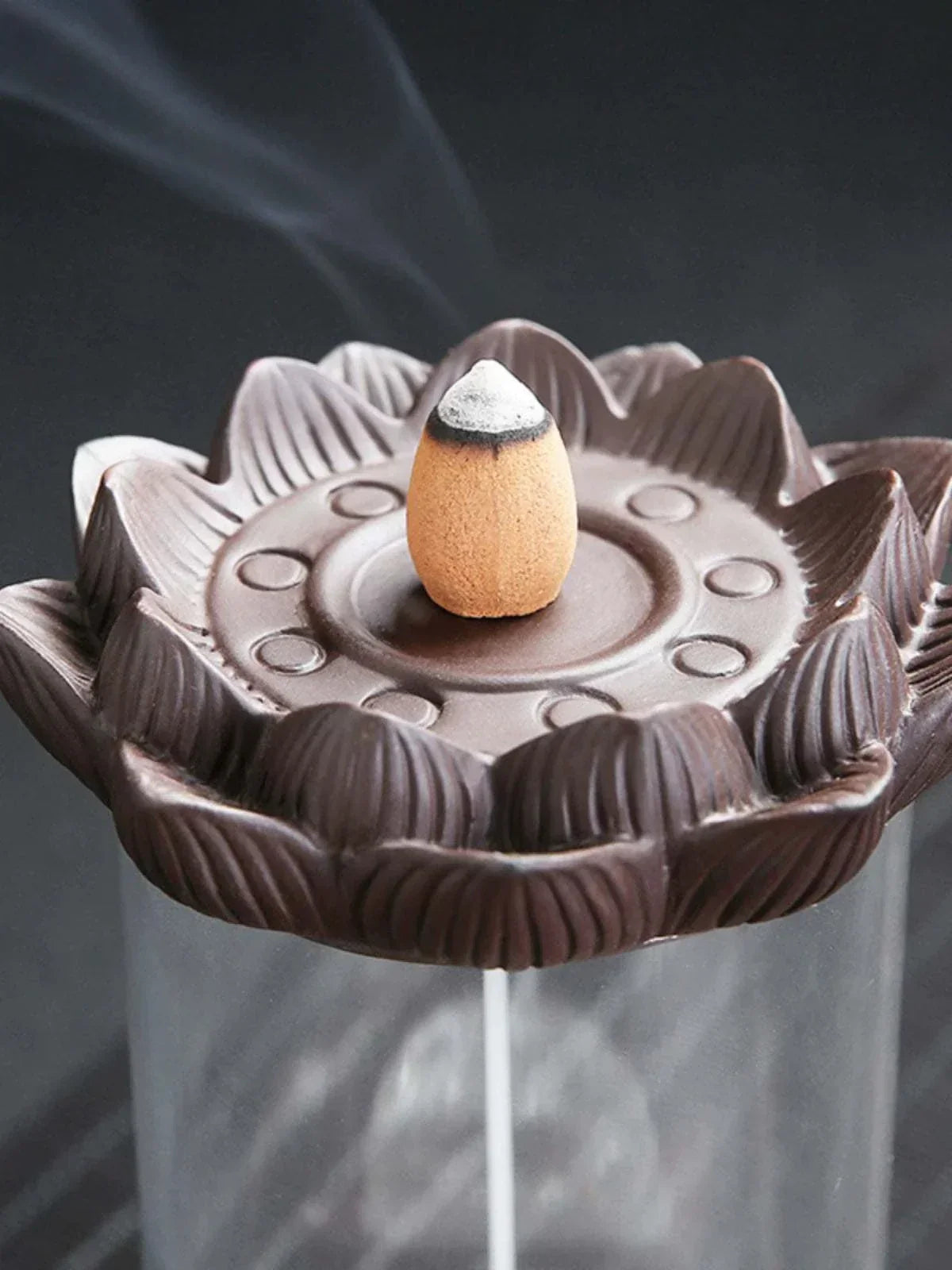 Backflow purple sand ceramic incense burner with lotus-shaped design and burning incense cone on top