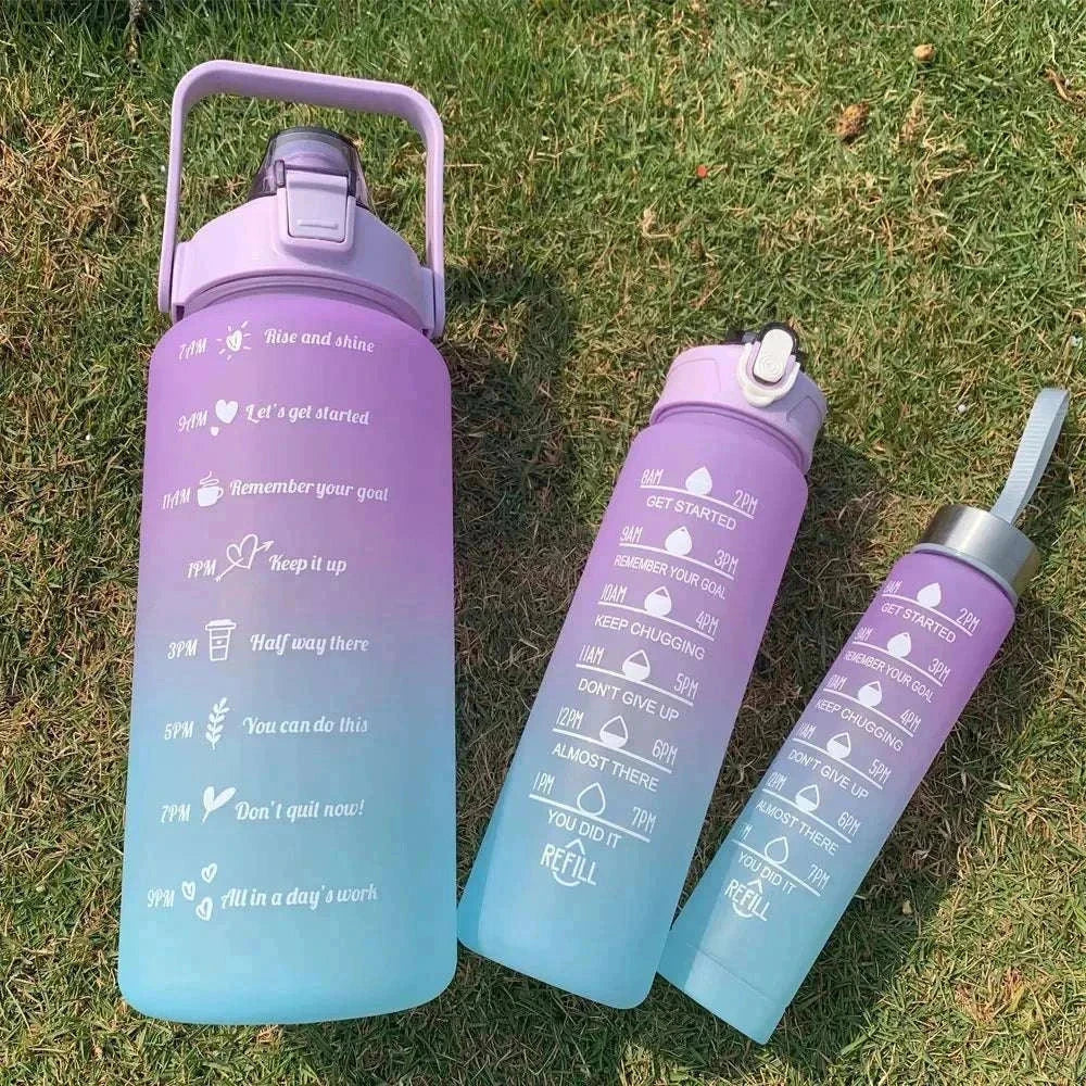 Purple and blue gradient water bottles with motivational quotes and time markers, reusable plastic sports bottles with straw and leakproof lids, eco-friendly and BPA-free.