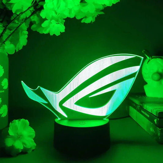 ROG 3D LED lamp with black base glowing green in dark gaming setup.