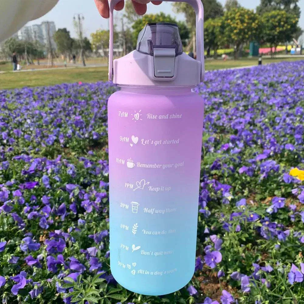 Gradient purple to blue reusable sports water bottle with motivational quotes and time markers, featuring a leakproof lid and straw.