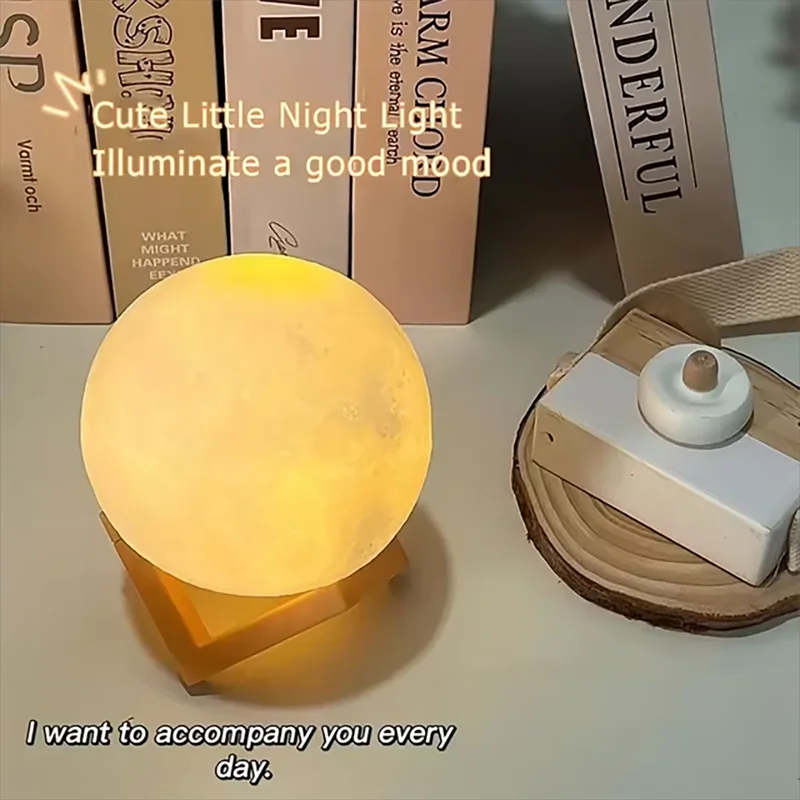 Cosmic Moon LED book light glowing warm on wooden stand beside decorative items and books