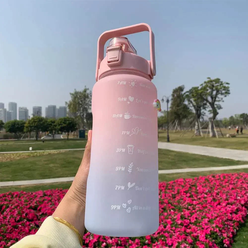 Reusable pink and purple gradient water bottle with motivational quotes and time markers for daily hydration goals.