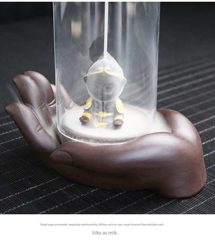 Backflow purple sand incense burner with ceramic Buddha hand holding glass lotus on dark surface