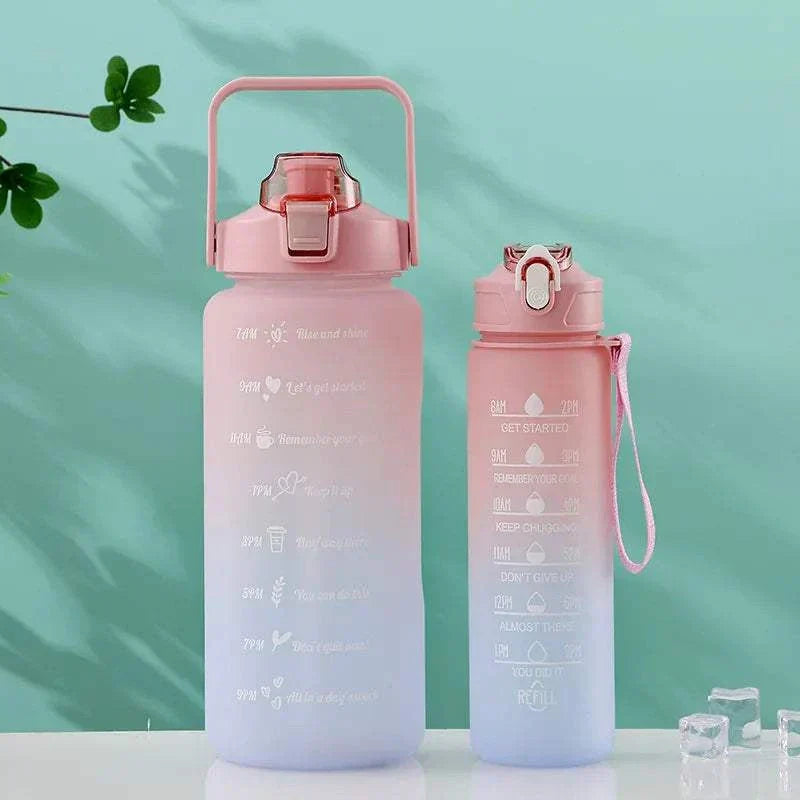 Pink and blue gradient sports water bottles with straw lids, featuring motivational quotes and time markers for tracking daily water intake.