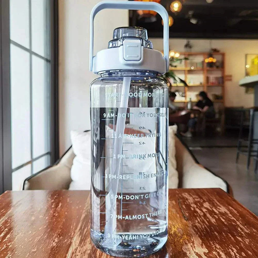 Clear sports water bottle with motivational quotes and time markers, featuring a sturdy handle and leak-proof lid for tracking daily water intake.
