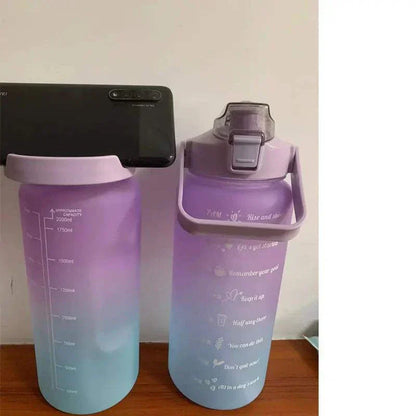 Purple and blue gradient sports water bottle with motivational quotes and time marker, reusable with straw lid, BPA-free plastic.