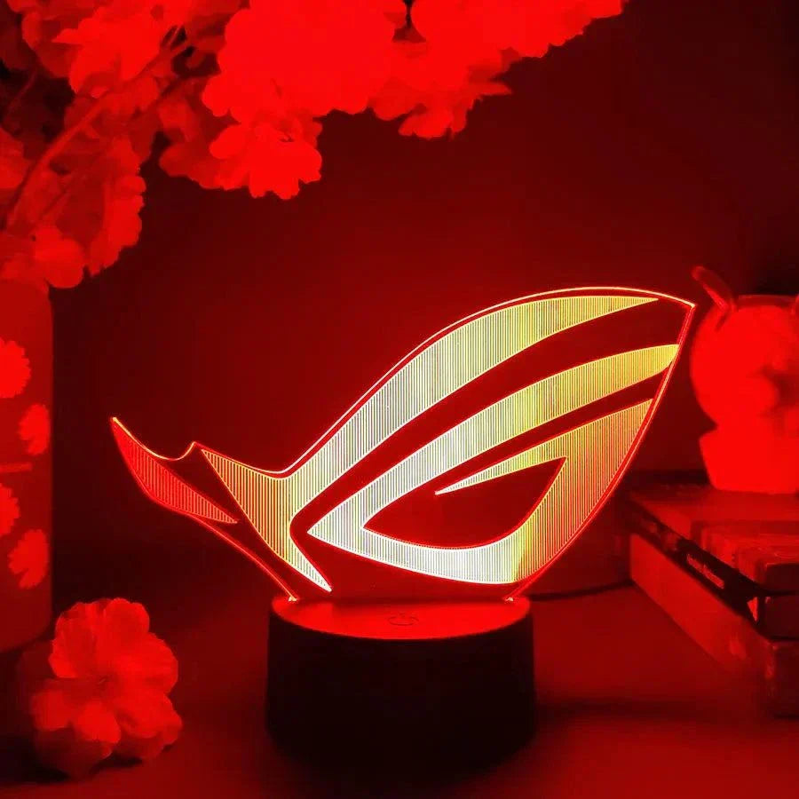 ROG 3D LED lamp with black base glowing red in a gaming setup decor