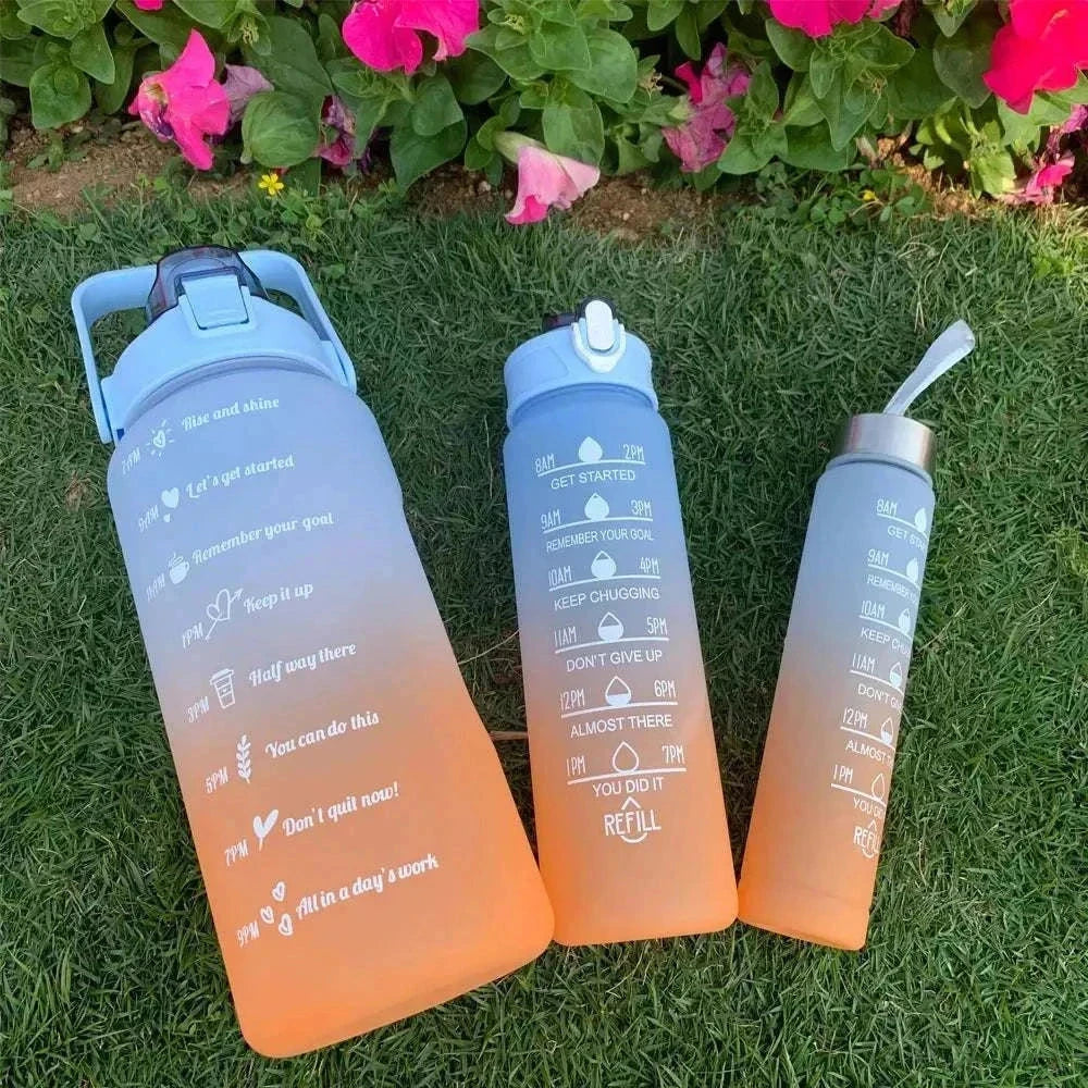 Set of orange to blue gradient water bottles with motivational quotes and time markers, made of plastic with straw lids, suitable for sports and hydration tracking.