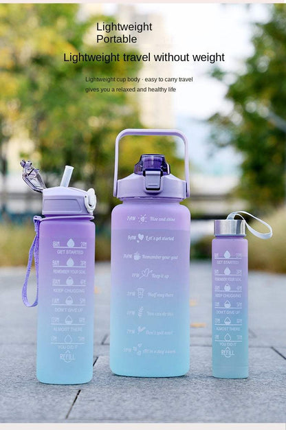 Set of reusable sports water bottles with motivational quotes and time markers in gradient purple and blue colors, featuring leakproof lids and straw-type mouthpieces for easy drinking.