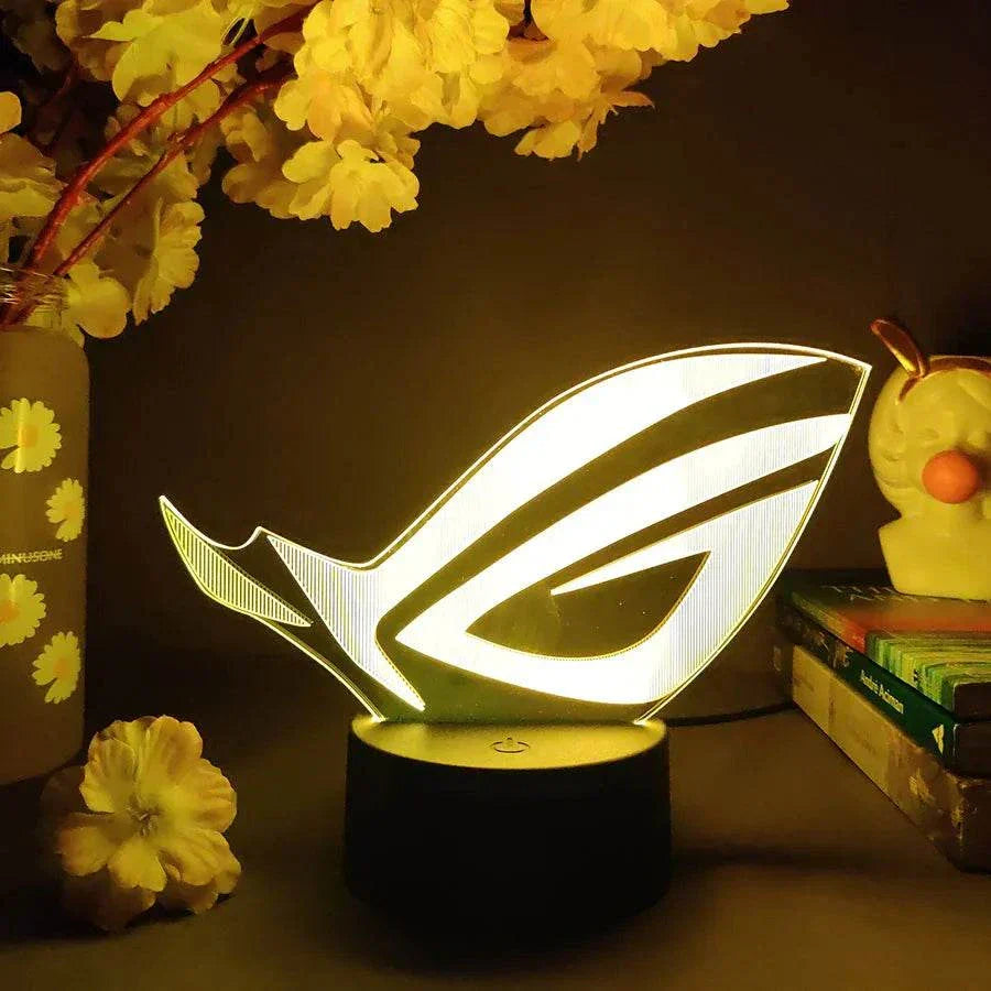 ROG 3D LED Lamp with black base glowing yellow in dark gaming setup decor
